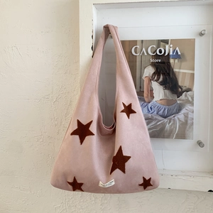 Detail of pink suede tote bag with brown star patches and high-quality woven label