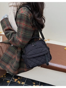 Dettaglio della borsa a tracolla trapuntata nera con materiale in nylon e tasche multiple