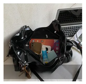 Intérieur spacieux du sac cabas noir brillant montrant le rangement pour iPad et objets