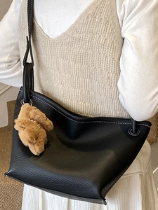 Sac seau minimaliste noir texture cuir litchi avec surpiqûres blanches et ours