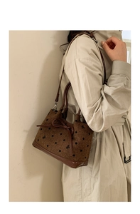 Détail du sac seau marron à pois avec broderie nœud et bandoulière en cuir élégante
