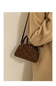 Detail of vintage brown polka dot fabric handbag with bow embroidery and leather trim