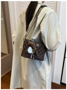 Quilted dark brown crossbody bag with leopard bow and heart charm on model