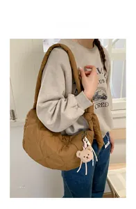 Detailansicht der braunen Stepptasche mit Herznaht und weichem Plüschbär-Anhänger