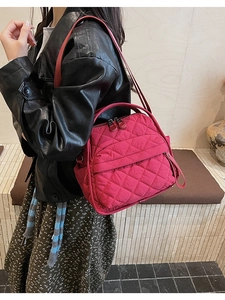 Dettaglio della borsa fucsia trapuntata con motivo a rombi e tracolla regolabile