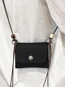 Minimalist black crossbody bag with flap closure and decorative wood beads on strap