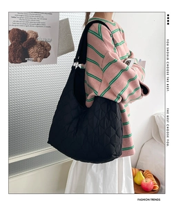 Détail du grand sac cabas noir matelassé avec un motif élégant en forme de cœur brodé