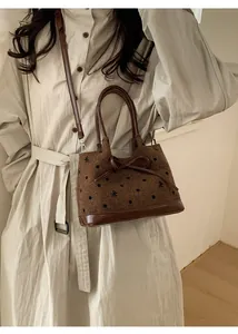 Détail du sac seau vintage marron à pois avec nœud et finitions en cuir chic