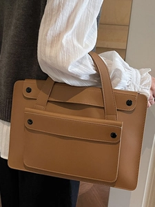 Caramel minimalist leather tote bag with front pocket and round metal button closure