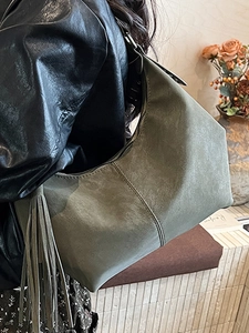 Olive green suede shoulder bag with long tassel detail and large capacity design