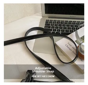 Détail montrant la bandoulière réglable en noir brillant avec boucle en métal argenté