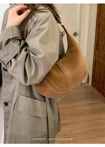 Detail of retro brown shoulder bag with white contrast stitching and minimalist retro vibe