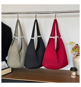 Gros plan de sacs cabas matelassés en nylon avec motifs de cœurs en gris, noir et rouge