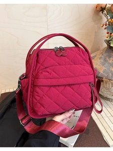Dettaglio della borsa in nylon trapuntato fucsia con motivi a rombi e manici robusti