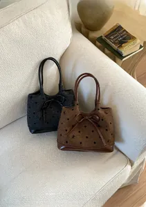 Détail de sacs cabas en tweed à pois, broderies et accents de nœuds en cuir