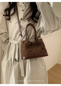 Détail du sac seau en tweed marron avec nœuds à pois noirs et bandoulière en cuir