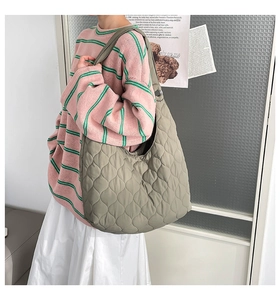 Détail du sac fourre-tout matelassé vert olive montrant la texture et la large bandoulière