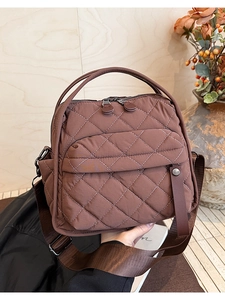 Dettaglio della borsa in nylon trapuntato marrone con cuciture a rombi bianchi e tasche