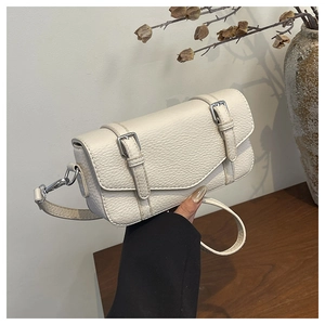 Detail of cream white pebbled leather shoulder bag with silver buckles and strap