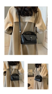 Detail of black leather crossbody bag featuring metal turn-lock and elegant top handle