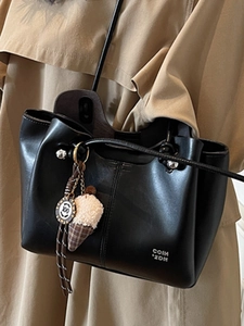 Minimalist black leather shoulder bag for women with ice cream charm and metal tag detail