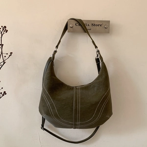 Detail of dark olive hobo bag featuring white contrast stitching and silver hardware