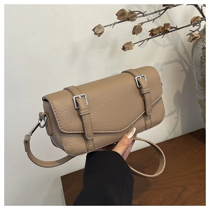 Detail of khaki pebbled leather bag featuring vintage buckle straps and silver hardware
