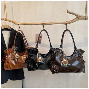 Détail de sacs à bandoulière rétro en similicuir marron et noir avec breloques d'oursons