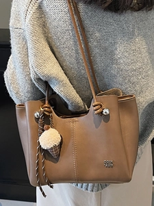 Brown leather tote bag with cream puff charm and silver logo for women's daily commute