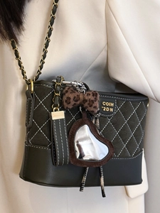 Quilted crossbody bag with gold chain and trendy charms on cream blazer outfit