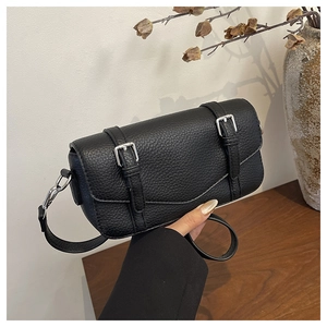 Close-up of black litchi pattern leather bag with square silver buckle detail