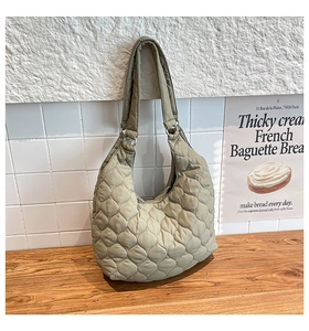 Détail d'un sac cabas matelassé vert sauge avec coutures en losanges et texture douce