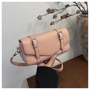 Detail of pink pebbled leather handbag with silver buckles and detachable shoulder strap