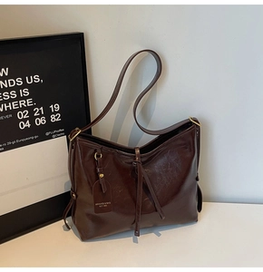Detail of dark brown wax leather tote with adjustable strap and vintage texture finish