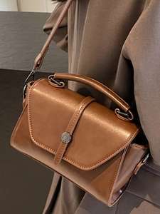 Minimalist caramel brown leather crossbody handbag with round metallic buckle for women