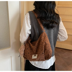 Detailansicht der braunen Cord-Tasche mit schwarzen Herz- und Schmetterlingsmustern