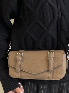 Minimalist beige pebble leather square crossbody bag with decorative silver buckle straps