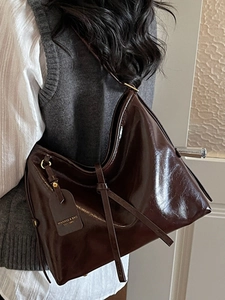 Brown oil wax leather tote bag for women with wide shoulder strap and leather tassel detail