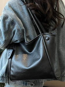 Minimalist black faux leather tote bag with large capacity and sleek shoulder straps