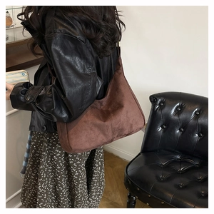 Detail of a large brown suede tote bag showing soft texture and spacious commuter style