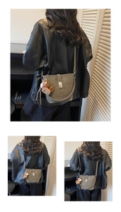 Detail of grey vintage bucket bag with pony charm and metallic buckle closure