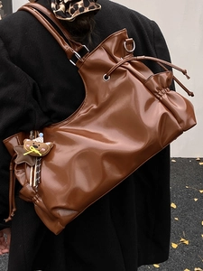 Sac bandoulière rétro en cuir marron brillant avec design croissant et breloque ours