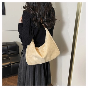Detail of beige suede tote bag showing soft hobo texture and brown leather strap on shoulder