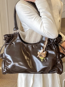 Sac à bandoulière marron foncé brillant avec détails de cordon et pendentif ours