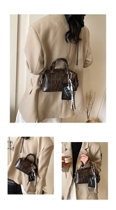 Detail of dark brown retro Boston bag with embossed letters and silk scarf accessory