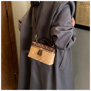 Detail of vintage quilted leather handbag styled with a long coat in a retro setting