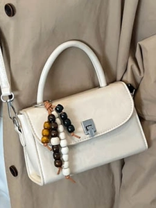 Creamy white crossbody handbag with wooden bead pendant and silver metal buckle