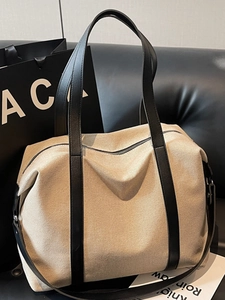 Große beige Canvas-Tragetasche mit schwarzen Ledergriffen und Schulterriemen