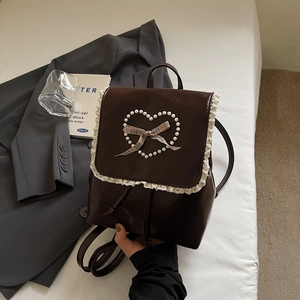 Détail du sac à dos marron en PU avec bordure en dentelle blanche et perles en forme de cœur
