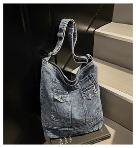 Dettaglio della borsa tote in denim blu vintage con doppie tasche e bottoni in metallo
